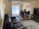 Living room with leather sofa, dining area, and hardwood floors at 2890 Rose Hill St, Strasburg, CO 80136