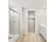 Bathroom featuring a glass-enclosed shower, white vanity, and wood-look flooring at 564 Red Rock Pl, Brighton, CO 80601