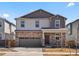 Charming two-story home featuring stone accents, a two-car garage, and a cozy front porch at 564 Red Rock Pl, Brighton, CO 80601