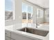 Bright kitchen with a stainless steel sink, white countertops, and a view of the backyard through a large sliding glass door at 564 Red Rock Pl, Brighton, CO 80601