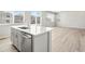 Modern kitchen island featuring a stainless steel sink, stainless steel dishwasher and beautiful flooring at 564 Red Rock Pl, Brighton, CO 80601