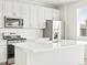 Bright kitchen with white cabinets, stainless steel appliances, quartz countertop, and modern subway tile backsplash at 564 Red Rock Pl, Brighton, CO 80601