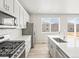 Modern kitchen with stainless steel appliances, quartz countertops, and a central island at 564 Red Rock Pl, Brighton, CO 80601