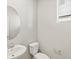 Modern powder room featuring a pedestal sink, a stylish mirror, and a window for natural light at 564 Red Rock Pl, Brighton, CO 80601