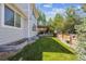 Landscaped backyard with a green lawn, a deck and fence with flower planters at 14049 Detroit Dr, Thornton, CO 80602