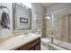 Well-lit bathroom with a glass enclosed shower, a sink with a dark wood cabinet and a large mirror at 14049 Detroit Dr, Thornton, CO 80602
