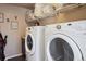 Bright laundry area features modern washer and dryer, plus shelving and storage at 14049 Detroit Dr, Thornton, CO 80602