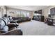 Large living room with a sectional sofa, media center, and a wall of windows at 14049 Detroit Dr, Thornton, CO 80602