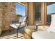 This sunny balcony offers two chairs, a metal table, and views of trees and buildings at 3291 Cascina Cir # D, Highlands Ranch, CO 80126