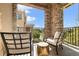 Outdoor balcony featuring a stone archway, wrought iron railing, and comfortable patio furniture at 3291 Cascina Cir # D, Highlands Ranch, CO 80126