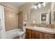 Well-lit bathroom featuring neutral tile, shower-tub combo, cherry cabinets, and a vanity sink at 3291 Cascina Cir # D, Highlands Ranch, CO 80126