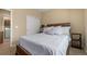 This cozy bedroom features a wood bed frame, plush carpet, closet, and access to the laundry room at 3291 Cascina Cir # D, Highlands Ranch, CO 80126