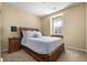 Comfortable bedroom features a wood bed frame, plush carpet, side table, and a bright window at 3291 Cascina Cir # D, Highlands Ranch, CO 80126