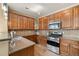 Warm kitchen featuring stainless steel appliances, tile backsplash, wood floors and dark wood cabinets at 3291 Cascina Cir # D, Highlands Ranch, CO 80126