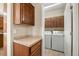 Functional laundry room features tile floors, overhead cabinets, countertops, and a washer and dryer at 3291 Cascina Cir # D, Highlands Ranch, CO 80126