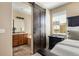 View of primary bedroom leading to the bathroom with a dark wood sliding barn door at 3291 Cascina Cir # D, Highlands Ranch, CO 80126