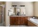 Bright primary bath with double sink vanity, jacuzzi tub, and warm tile flooring at 3291 Cascina Cir # D, Highlands Ranch, CO 80126