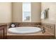 Relaxing soaking tub with tile surround and natural light from window at 3291 Cascina Cir # D, Highlands Ranch, CO 80126