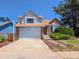 Two-story home featuring a two-car garage, brick accents, and landscaped yard at 20391 E 42Nd Ave, Denver, CO 80249