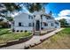 Exterior view of a welcoming home featuring a charming walkway, flower pots, and mature trees at 17004 E Tennessee Dr # 212, Aurora, CO 80017