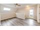 Bright living area with light-colored walls and wood-style floors, plus a skylight and door to exterior at 17004 E Tennessee Dr # 212, Aurora, CO 80017