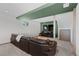 Finished basement featuring a brown leather couch, large tv, and green accent wall at 12017 W 54Th Dr, Arvada, CO 80002