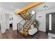 Bright foyer with a modern staircase, hardwood floors, and a stylish bench at 12017 W 54Th Dr, Arvada, CO 80002