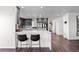 Modern kitchen featuring a large island with bar seating, stainless steel appliances, and sleek gray cabinetry at 12017 W 54Th Dr, Arvada, CO 80002