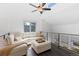 Lofted living room featuring a ceiling fan, large windows, and comfortable seating at 12017 W 54Th Dr, Arvada, CO 80002