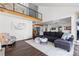 Spacious living room featuring a black metal stair railing, dark floors, and large sofa perfect for gatherings at 12017 W 54Th Dr, Arvada, CO 80002