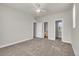 Large bedroom with neutral carpet, ceiling fan, and two doorways leading to a bathroom and another room at 3372 Central Park Blvd, Denver, CO 80238