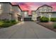 Three-unit stucco home with a spacious driveway and three garages against a twilight sky at 3372 Central Park Blvd, Denver, CO 80238