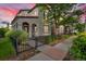 View of the side yard that has a walkway with greenery and a wrought iron fence and sitting area at sunset at 3372 Central Park Blvd, Denver, CO 80238