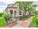 View of the side yard that has a walkway with greenery and a wrought iron fence and sitting area at 3372 Central Park Blvd, Denver, CO 80238