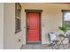Inviting covered front porch with decorative black chairs and table and vibrant red door at 3372 Central Park Blvd, Denver, CO 80238