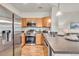 Modern kitchen with stainless steel appliances, wooden cabinets, and open floor plan to living area at 3372 Central Park Blvd, Denver, CO 80238