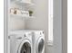 Close up of modern washer and dryer in the laundry room featuring open shelving for storage at 3372 Central Park Blvd, Denver, CO 80238