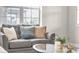 A closer view of the gray sofa, showing decorative pillows, a coffee table, and natural light at 3372 Central Park Blvd, Denver, CO 80238