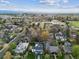 Aerial view of a neighborhood with lush green trees and a cityscape in the distance at 10 Cherry St, Denver, CO 80220