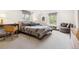 Bedroom featuring large bed with striped bedding, sitting area, and desk at 10 Cherry St, Denver, CO 80220