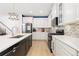 Bright kitchen featuring white countertops, black appliances, herringbone backsplash, and modern light fixtures at 3924 Alamosa Ct, Brighton, CO 80601