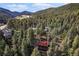 Secluded cabin nestled among towering evergreen trees in a lush mountain setting at 5672 Santa Clara Rd, Indian Hills, CO 80454