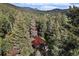 Cabin situated amid a dense forest with mountain views in the background at 5672 Santa Clara Rd, Indian Hills, CO 80454