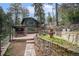 Exterior of a cabin home, showcasing a stone retaining wall, covered picnic area, and natural landscaping at 5672 Santa Clara Rd, Indian Hills, CO 80454
