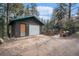 Exterior shot of a log cabin style garage with a charming gated walkway at 5672 Santa Clara Rd, Indian Hills, CO 80454