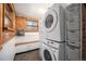 Efficient laundry room with stacked washer/dryer and wire storage baskets at 5672 Santa Clara Rd, Indian Hills, CO 80454