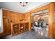 Living room with wood paneling, hardwood floors, and stylish decor, leading into an open kitchen space at 5672 Santa Clara Rd, Indian Hills, CO 80454
