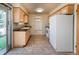 Functional kitchen featuring light wood cabinetry, tile floors and white appliances at 1501 E Panama Dr, Centennial, CO 80121