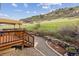 Backyard patio with a wooden deck, stone accents, and scenic hillside views at 7141 Red Mesa Dr, Littleton, CO 80125