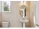 Powder room features a pedestal sink, toilet and window with natural light at 7141 Red Mesa Dr, Littleton, CO 80125